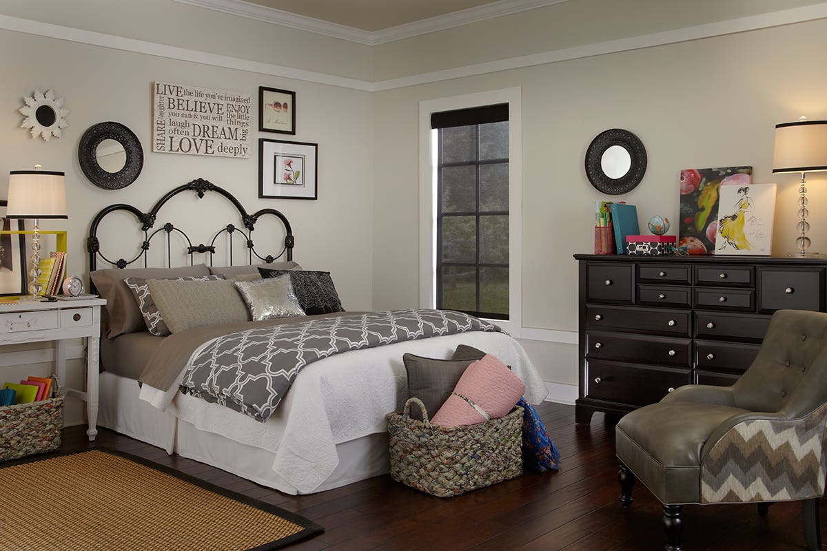 Young woman's bedroom with fully closed sheer roller shades in charcoal color