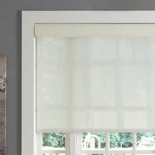 White automatic roller shades in window