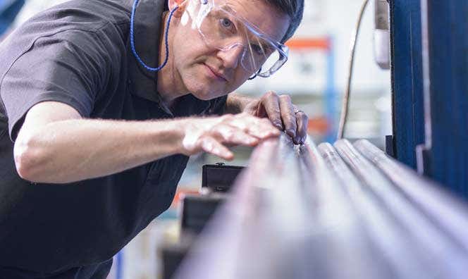 Man working with piping and wearing protective eye wear